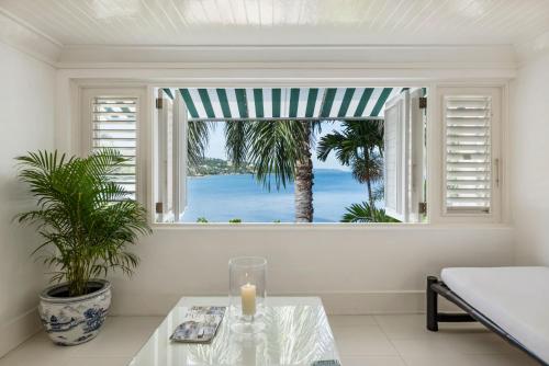 a room with a window with a view of the ocean at Round Hill Hotel & Villas in Montego Bay