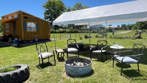 a group of chairs and a fire pit with a tiny house at Glamping tent on farm Mountain views in Edinburg