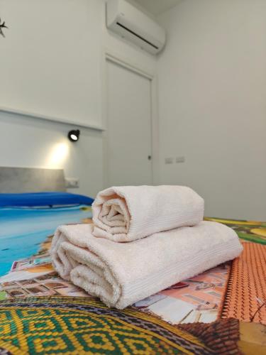 a pile of towels sitting on top of a bed at Swallow Room Holidays in Massa Lubrense