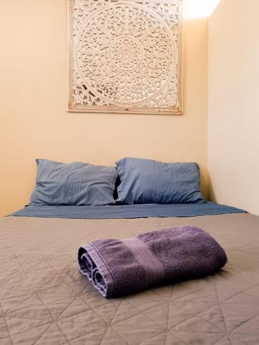 a bed with a purple blanket laying on it at Dalia Room, Paseo Durango in Durango