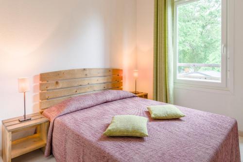 En eller flere senge i et værelse på Lagrange Vacances Les Terrasses du Lac