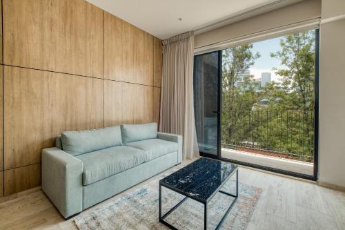 a living room with a couch and a glass table at Myla Chapultepec in Mexico City