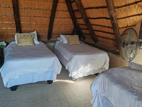 two beds in a room with white sheets and pillows at Mali Mali Safari Lodge House 5 in Hoedspruit