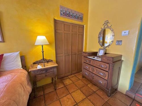 a bedroom with a bed and a dresser and a mirror at Casa Benavides Inn in Taos