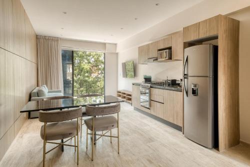 a kitchen with a refrigerator and a table and chairs at Myla Chapultepec in Mexico City