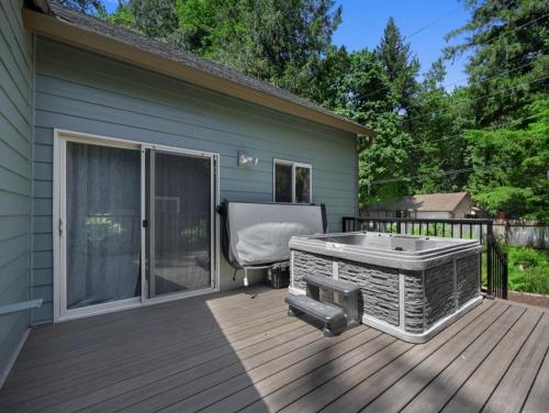 a hot tub on a deck next to a house at Lupine Chalet in Rhododendron