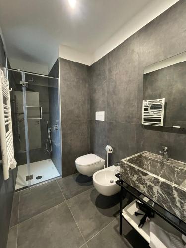 a bathroom with a toilet and a sink and a shower at Villa Tosto in Castelluzzo