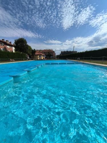 a large blue swimming pool with a cloudy sky at La atalaya de Coto in Salinas