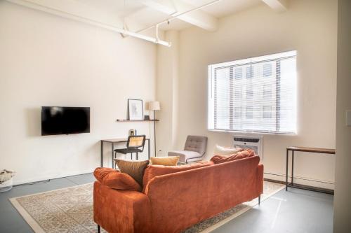 Una sala de estar con un sofá y un televisor. en Westown Studio Apt Near Fiserv, Baird, and Theater District, en Milwaukee