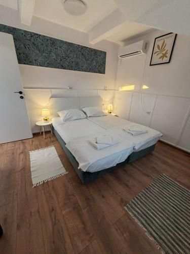 Un dormitorio con una cama grande y suelo de madera. en White House Apartments - Forest, en Haskovo