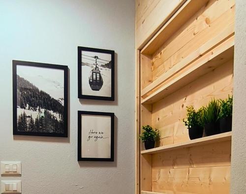 a room with three framed pictures on a wall at Villa Rosina in Saint Vincent
