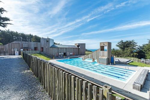 a swimming pool next to a wooden fence at Neel Nirvana - Deck With BBQ & Community Pool in Sea Ranch