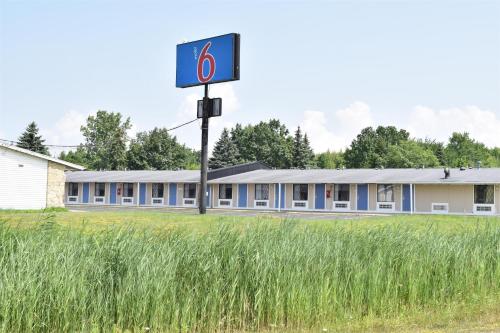 a building with a sign in the middle of a field at Motel 6-Hamburg, NY in Hamburg