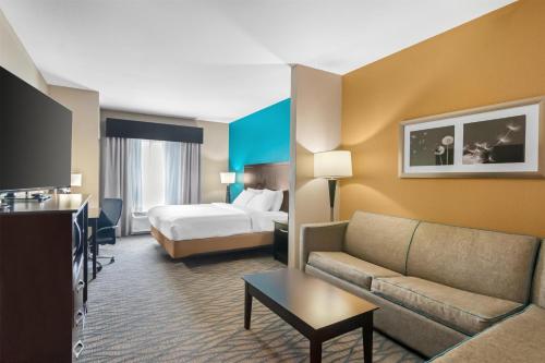 a hotel room with a couch and a bed at Best Western Plus Hiawatha Hotel in Hiawatha