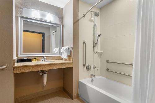 a bathroom with a tub and a sink and a toilet at Best Western Plus Hiawatha Hotel in Hiawatha