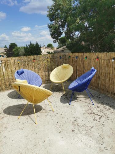 un groupe de trois chaises devant une clôture dans l'établissement 50m2, 4 personnes , jacuzzi et sauna privatif, à Piolenc