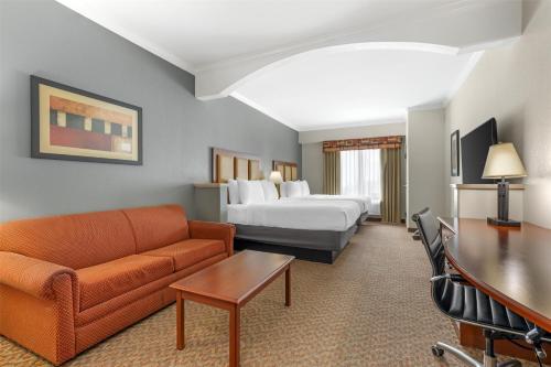 a hotel room with a couch and a bed at Best Western Plus Waxahachie Inn & Suites in Waxahachie