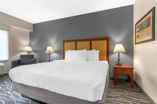 a hotel room with a large bed and two lamps at Best Western Plus Waxahachie Inn & Suites in Waxahachie