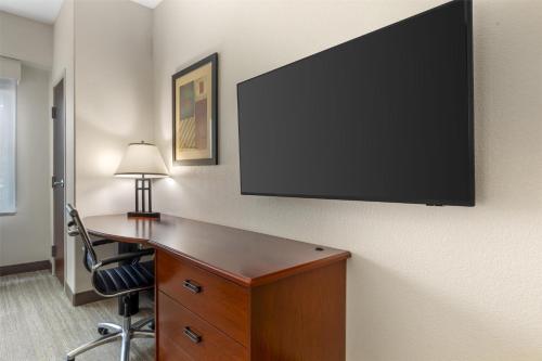 a room with a desk and a flat screen tv on a wall at Best Western Plus Waxahachie Inn & Suites in Waxahachie