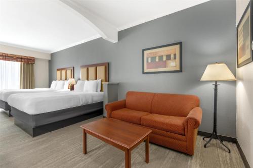 a hotel room with a bed and a couch at Best Western Plus Waxahachie Inn & Suites in Waxahachie