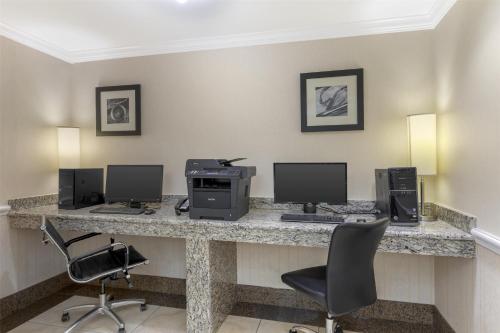a room with a desk with three computers and chairs at Best Western Plus Waxahachie Inn & Suites in Waxahachie
