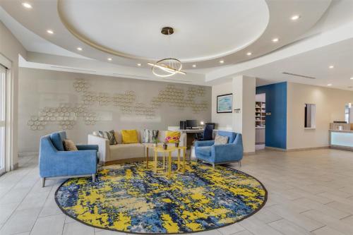 a lobby with a couch and chairs and a rug at Best Western Plus Mid County in Port Arthur