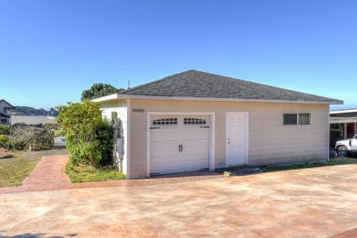 a garage with white doors and a driveway at Lucky Ewe - Ocean View Retreat in Gualala