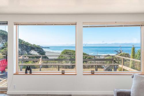 a room with two windows looking out at the ocean at Ocean Bungalow - Tesla EV Station & Near Trails in Gualala