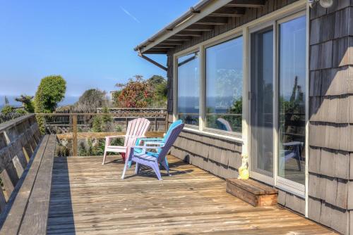 a deck with two chairs and a table on it at Ocean Bungalow - Tesla EV Station & Near Trails in Gualala