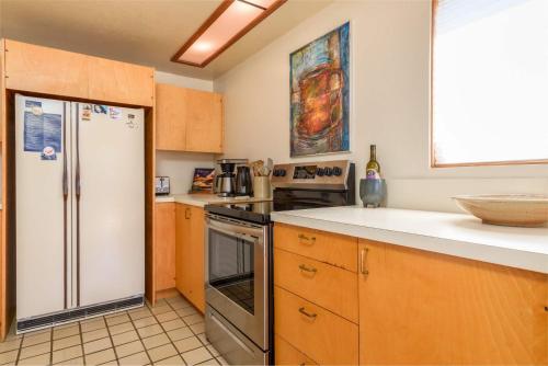 a kitchen with a stainless steel refrigerator and wooden cabinets at Incredible Sea Ranch Escape for 6 With Ocean Trail in Sea Ranch