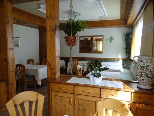 a kitchen with a table and chairs and a mirror at Hotel Mondeval in Selva di Cadore