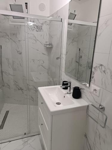 a white bathroom with a sink and a shower at Marilissa Home in Bari