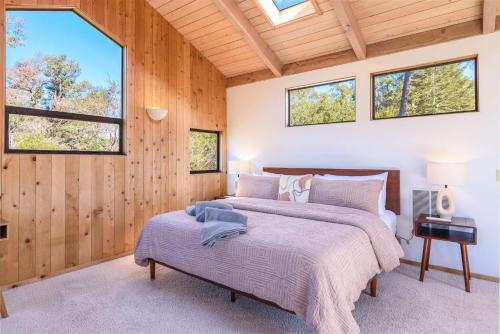 a bedroom with two beds in a room with windows at Charming 3 BD Family Home for 6 with Ocean Views & Trail Access in Sea Ranch
