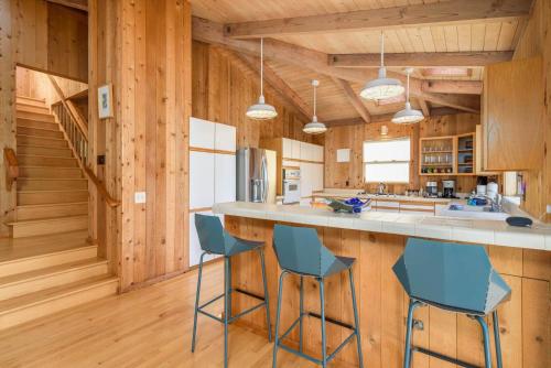 a kitchen with wooden walls and blue bar stools at Charming 3 BD Family Home for 6 with Ocean Views & Trail Access in Sea Ranch