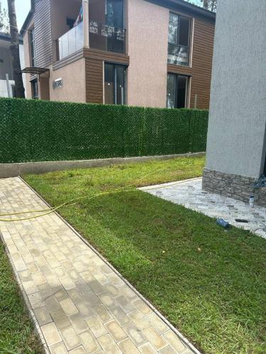 a walkway in front of a building with a hedge at Magnetoria in Urekis Sadguri