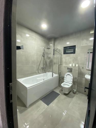a bathroom with a bath tub and a toilet at Magnetoria in Urekis Sadguri