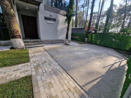 a house with a driveway in front of a building at Magnetoria in Urekis Sadguri