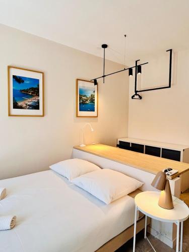 カーニュ・シュル・メールにあるSuite Èze - Coliving, Parking & Breakfastの白い部屋にテーブルのあるベッドが2つ