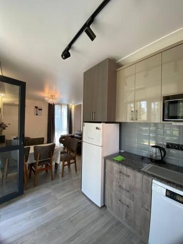 a kitchen with a white refrigerator and a dining room at Magnetoria in Urekis Sadguri
