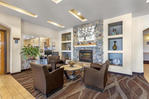 a living room with a fireplace and a table and chairs at Best Western Firestone Inn & Suites in Longmont