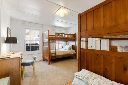 a bedroom with two bunk beds and a desk at Belleview Lakefront by Tahoe Getaways - Hot Tub, Pier, Buoy and Guest House in Homewood
