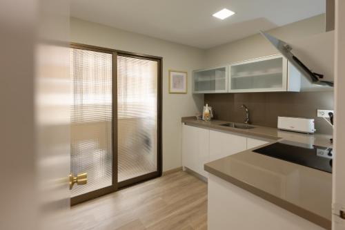 Una cocina con gabinetes blancos y una ventana. en Comeback A un Suspiro del Mar, en La Herradura