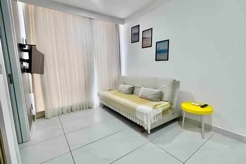 a white room with a bed and a yellow table at Flat pé na areia c/vista 406B Branco Haus -MyFlats in Tambaú
