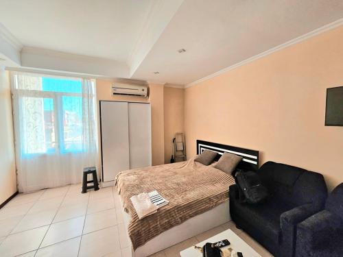 a bedroom with a bed and a couch at apartment Leyla in Batumi