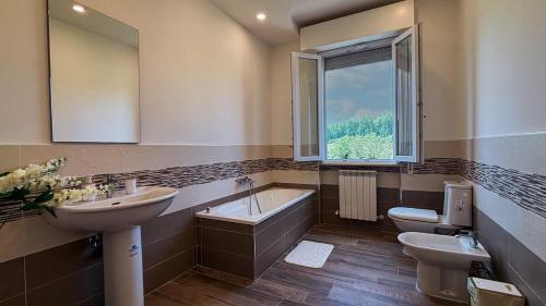 a bathroom with a sink and a tub and a toilet at Villa Lilla 3 in Bigliolo