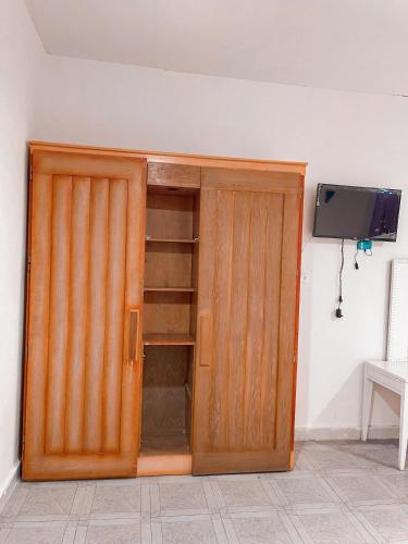 a wooden cabinet with a tv on a wall at Brother Hotel Dahab in Dahab