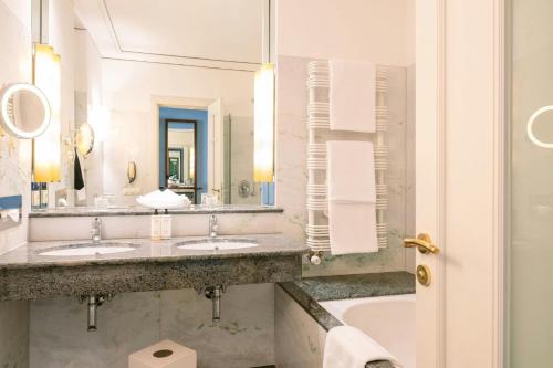 a hotel bathroom with two sinks and a tub at Louis C Jacob, Hamburg, Autograph Collection in Hamburg