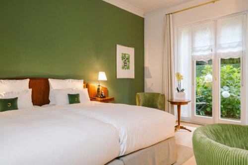 a bedroom with a white bed and a green wall at Louis C Jacob, Hamburg, Autograph Collection in Hamburg