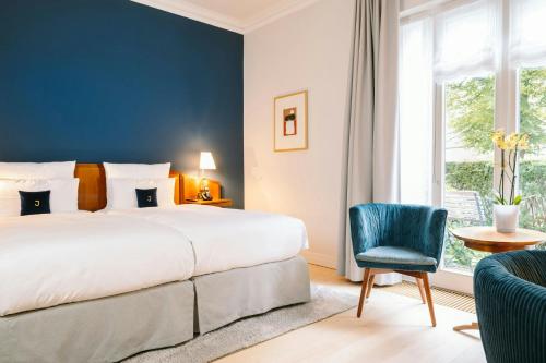 a bedroom with a bed and a chair and a window at Louis C Jacob, Hamburg, Autograph Collection in Hamburg