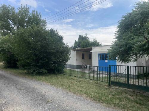 a white house with a blue door and a fence at SióSpot in Siófok
